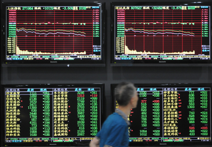 Man walks past screens showing stock information at a brokerage house in Jiujiang