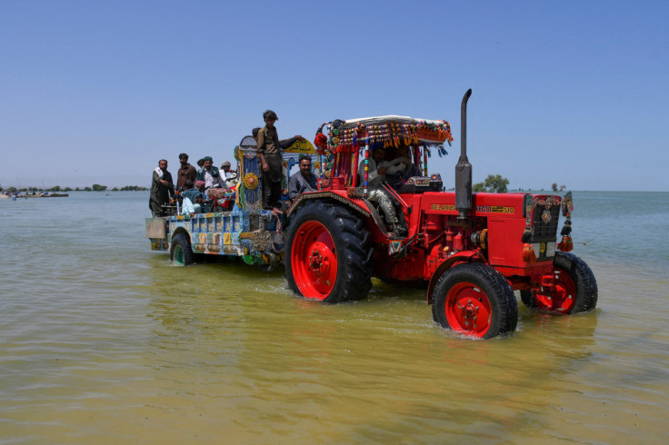 Villagers board a tractor trolley as they travel amid flood water, following rains and floods during the monsoon season in Bajara village, Sehwan