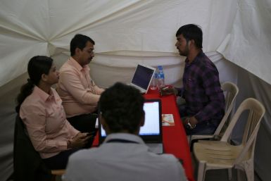 A job seeker is interviewed by human resource managers at a job fair in Chinchwad