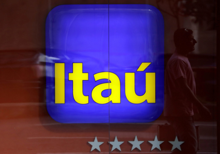 Man is reflected in an Itau branch window in Rio de Janeiro