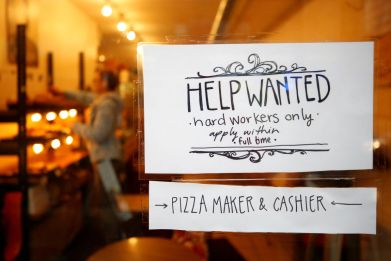 A "Help wanted" sign is seen in the window of a bakery in Ottawa