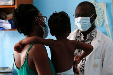 Doctor Charles Eblin prepares to take care of a girl with malaria at his clinic Centre de sante sainte Marie de Marcory in Abidjan