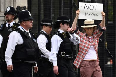 One protester was ushered away from the UK parliament for holding up a sign against King Charles III
