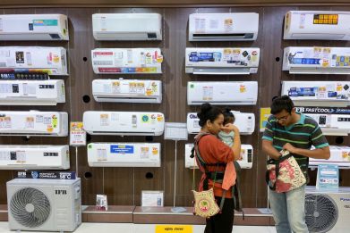 People shop for an air conditioner inside an electronics store in Mumbai
