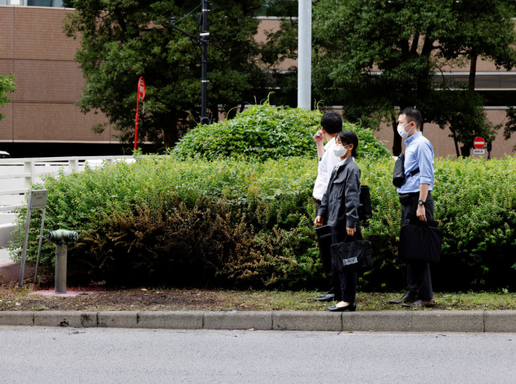 Unidentified officials check the site where a man who was protesting a state funeral for former Japanese Prime Minister Shinzo Abe set himself on fire, near Prime Minster Fumio Kishida's official residence in Tokyo