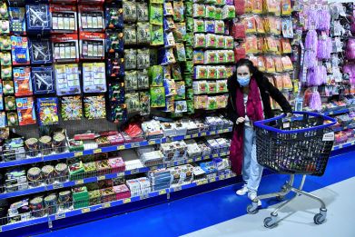 A shopper wearing a face masks pushes a trolley in a discount shop in Dublin