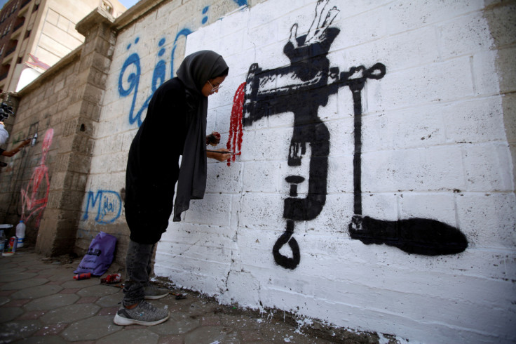 An artist paints a mural as part of the "Cholera" campaign to depict the suffering of cholera patients in Sanaa