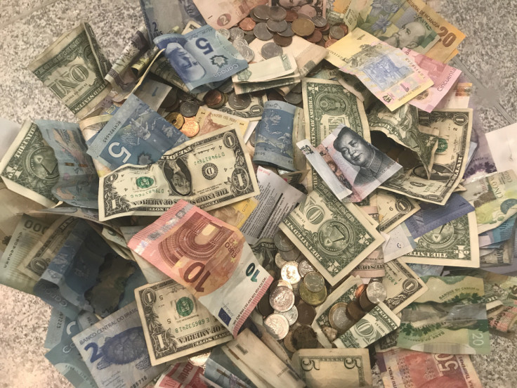 U.S. dollars and other world currencies lie in a charity receptacle at Pearson international airport in Toronto