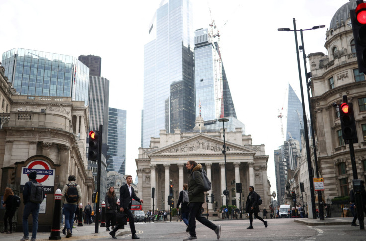 People walk through the City of London financial district during rush hour in London