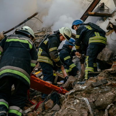 Ukrainian firefighters remove the body of a civilian killed after a strike in Zaporizhzhia
