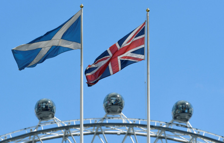 The Scottish Saltire flag flies next to the British Union Jack flag with the London Eye wheel seen behind in London