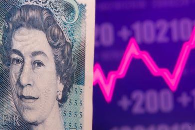 A British Pound banknote is seen in front of displayed stock graph in this illustration