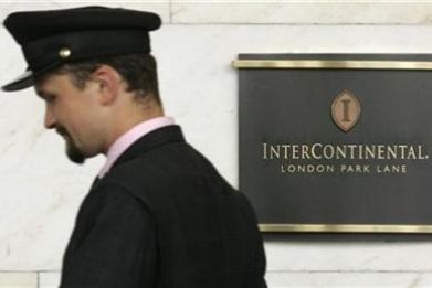 A porter passes a sign for the InterContinental Hotel Park Lane in London