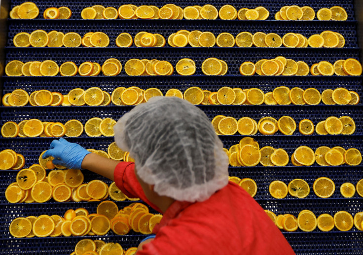 A worker prepares orange slices for drying at the Nim's Fruit Crisps factory, in Sittingbourne