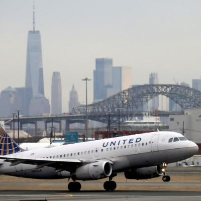 A United Airlines passenger jet takes off with New York City as a backdrop