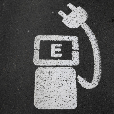 A battery charger sign for electric cars is painted on the ground of a parking ground near the soccer stadium in Wolfsburg