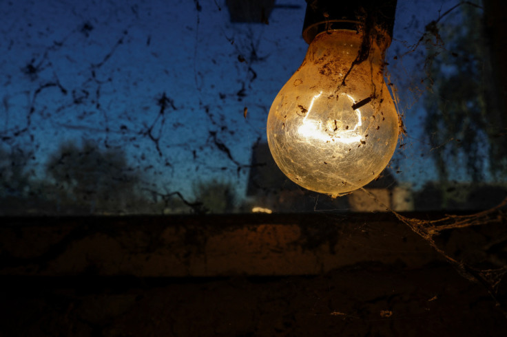 An incandescent light bulb is covered in spider webs inside a stable in Vasilati