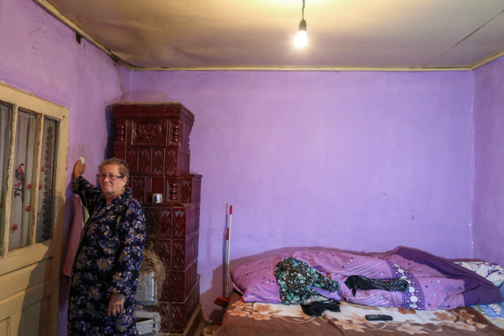 Georgeta Ichim, 67, switches on a light bulb in her house in Vasilati