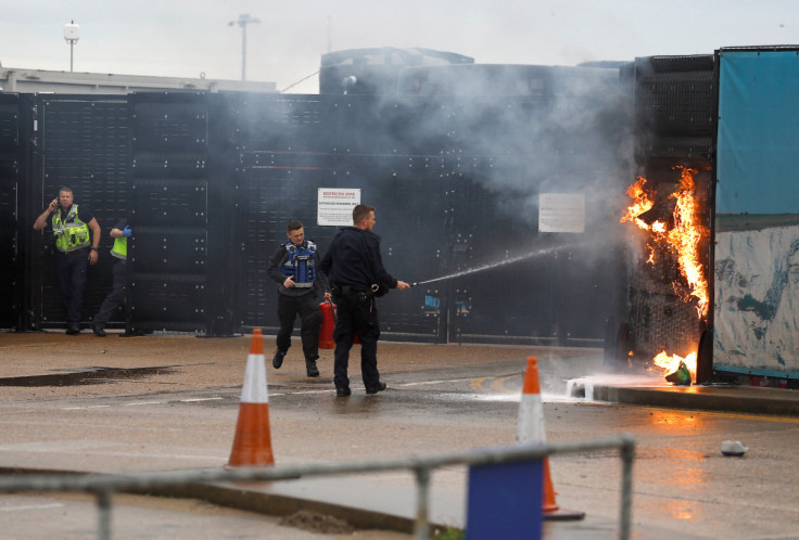 Members of the military and UK Border Force extinguish a fire from a petrol bomb, targeting the Border Force centre in Dover