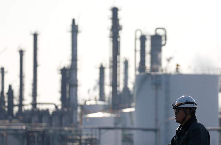 A worker walks near a factory at the Keihin industrial zone in Kawasaki