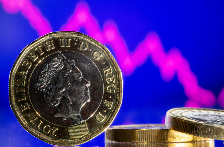 British pound coins are seen in front of displayed stock graph in this illustration