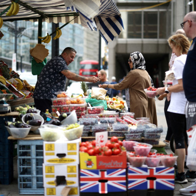 A person buys produce from a fruit and vegetable market stall in central London
