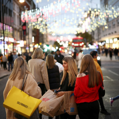 People walk along Oxford Street illuminated with Christmas lights in London