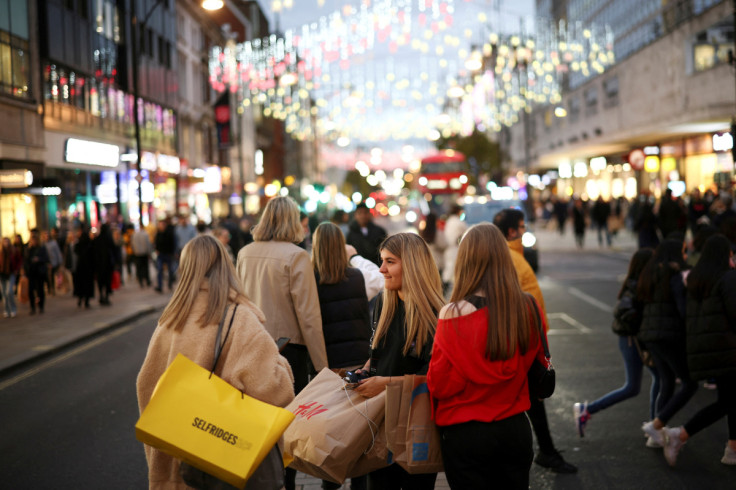 People walk along Oxford Street illuminated with Christmas lights in London