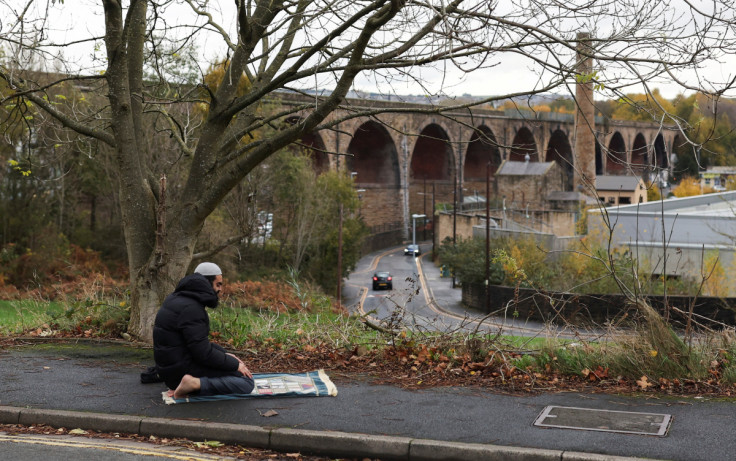 A man prays in the street in Burnley, England