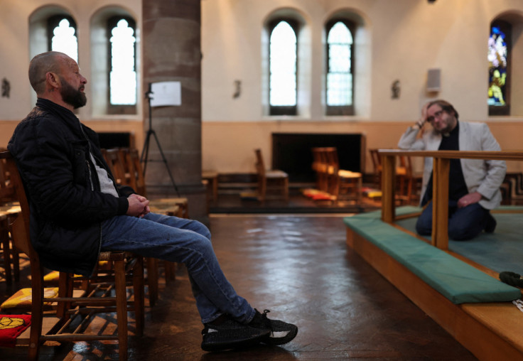 Vicar Alex Frost listens to Mark John Marsden, a parishioner of Matthew the Apostle Church, as they talk inside the church in Burnley