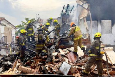 Firefighters work at the site where a light aircraft crashed, leaving eight people dead in the Belen Rosales neighborhood in Medellin, Colombia