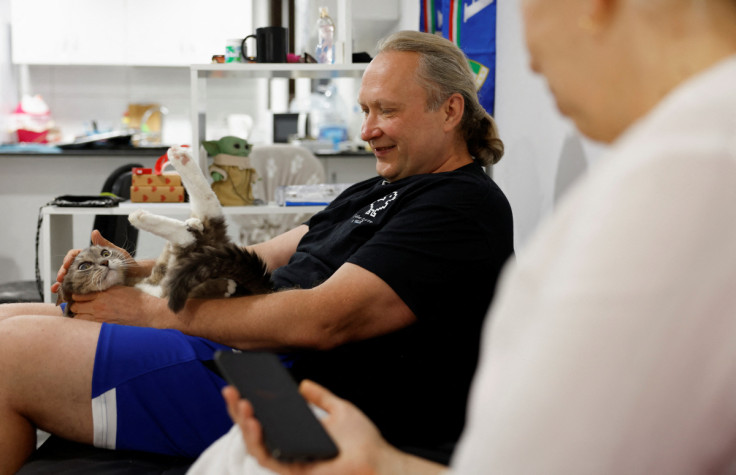 Victor Varlamov and his wife Nataly Ludina sit with their cat at their house in Las Palmas de Gran Canaria