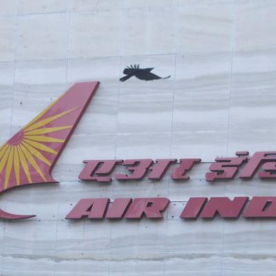 A bird flies over a logo of Air India airlines at the corporate headquarters in Mumbai