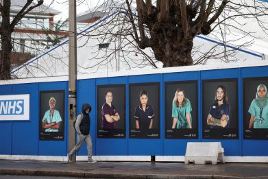 Images of National Health Service (NHS) workers displayed on hoardings outside a temporary field hospital at St George's Hospital in London