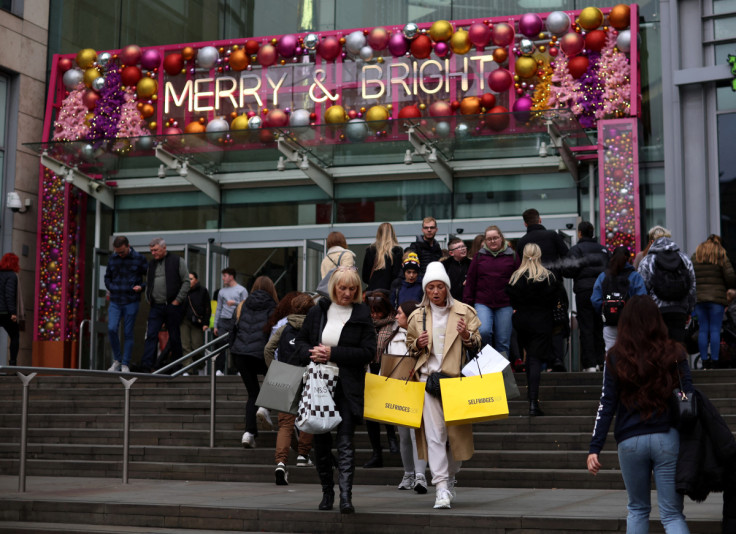 People carrying shopping bags walk out of a shopping centre in Manchester
