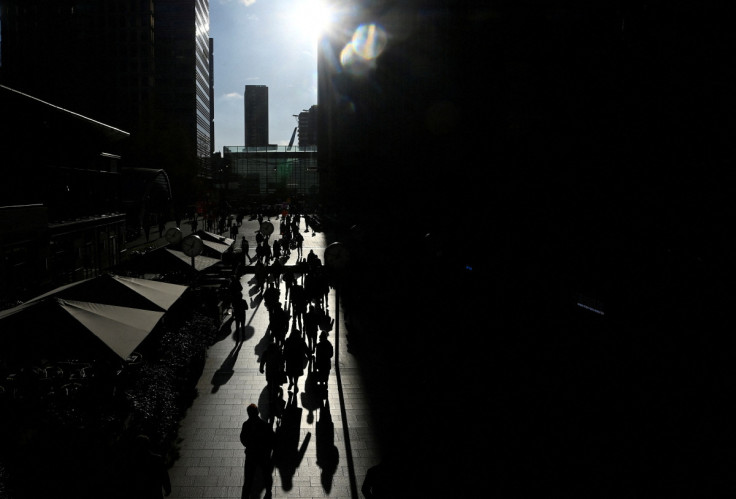 Workers walk through the Canary Wharf financial district in London