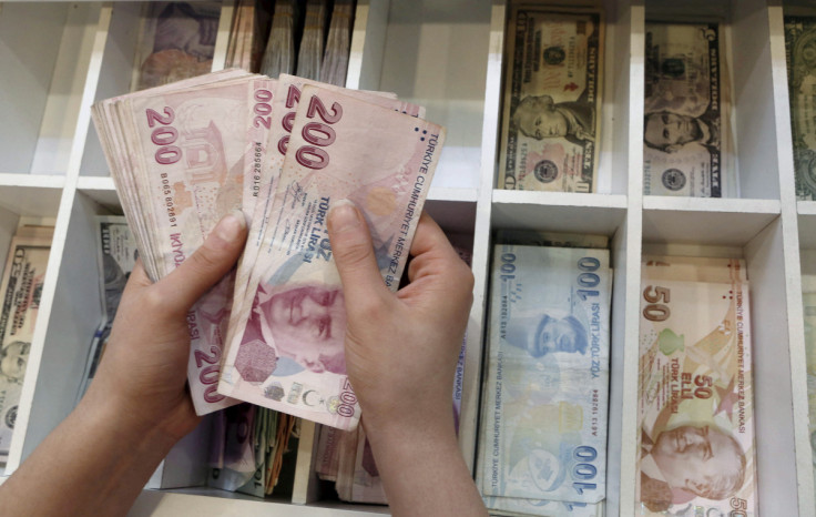A money changer counts Turkish lira bills at an currency exchange office in central Istanbul, Turkey