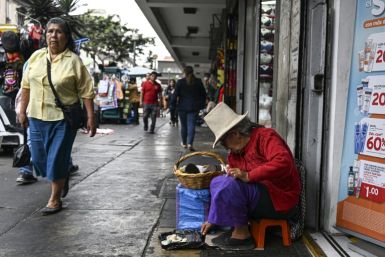 A vendor sells her goods on a street in downtown  Lima on December 23, 2022