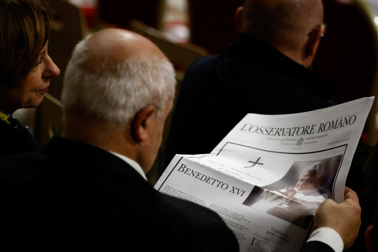A faithful reads "Osservatore Romano" newspapers at the Vatican