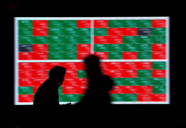 Passersby walk past an electric stock quotation board outside a brokerage in Tokyo