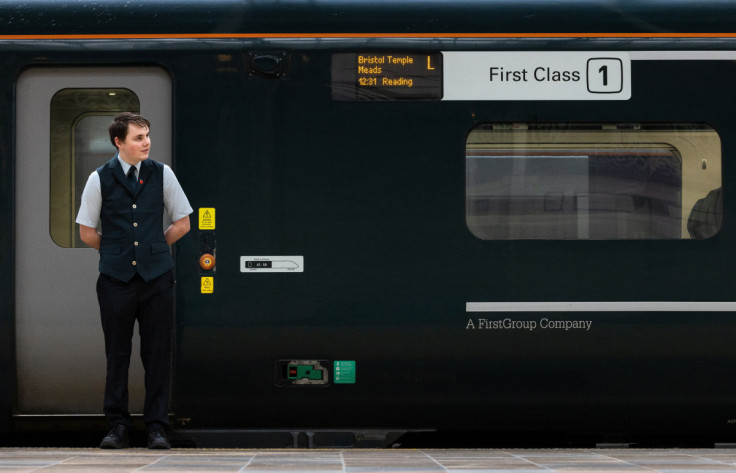 A GWR worker waits at a First Class carriage for passengers at Paddington Station  in London