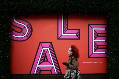 A person walks past sale signage on Oxford Street during the second day of Boxing Day sales, in London