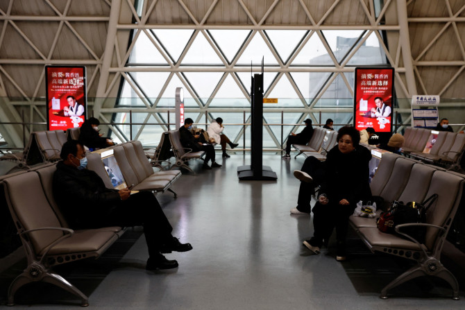 Travellers wait to board their plane at Chengdu Shuangliu International Airport amid a wave of the COVID-19 infections