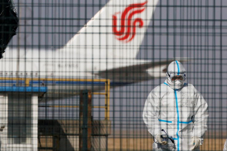 A worker in a protective suit walks near a plane of Air China airlines at Beijing Capital International Airport as coronavirus disease (COVID-19) outbreaks continue in Beijing