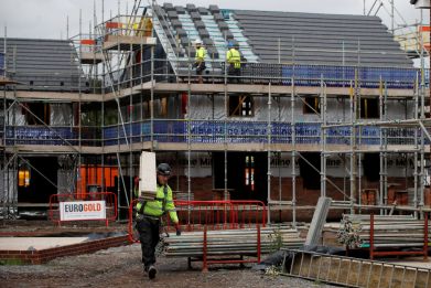 Builders work on a new Barratt Homes housing development near Warrington, Britain