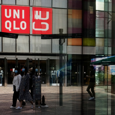 Women walk past a store of the Fast Retailing's fashion chain Uniqlo, in Beijing
