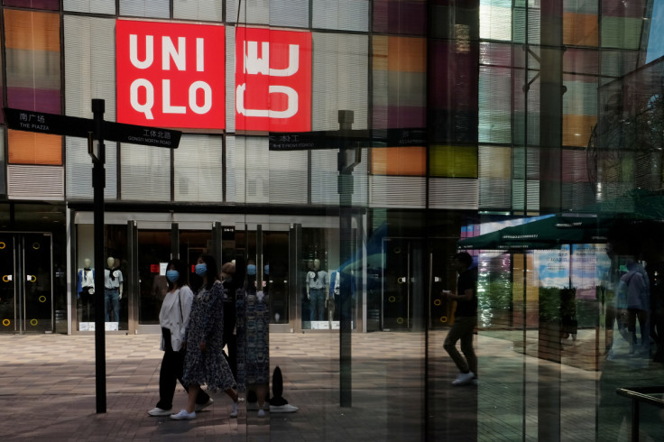 ビジネス情報 Women walk past a store of the Fast Retailing's fashion chain Uniqlo, in Beijing