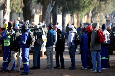 Job seekers stand outside a construction site in Eikenhof, south of Johannesburg,