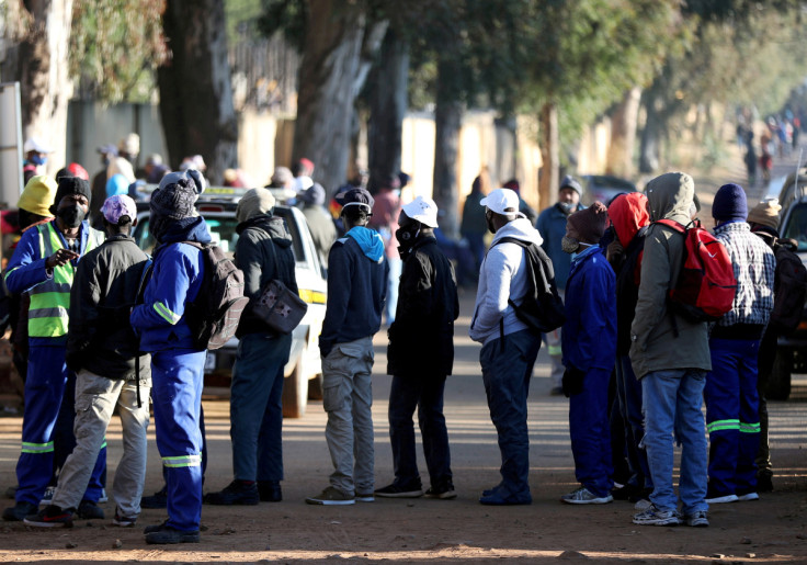 Job seekers stand outside a construction site in Eikenhof, south of Johannesburg,