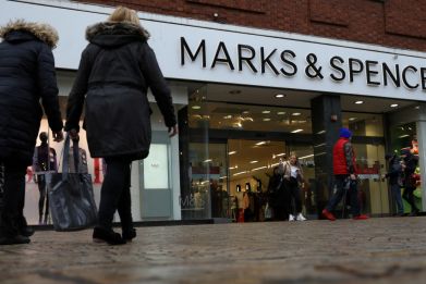 Shoppers walk past a branch of Marks and Spencer in Altrincham, Britain